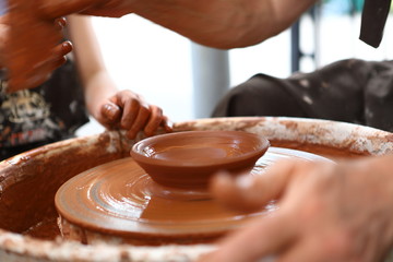Master of ceramics. We work with clay. The master ceramist teaches the student. Craftsman hands sculpts clay
