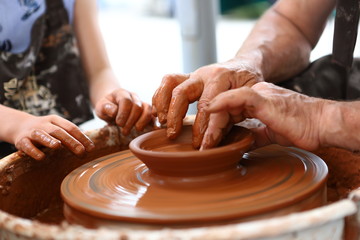 Master of ceramics. We work with clay. The master ceramist teaches the student. Craftsman hands sculpts clay