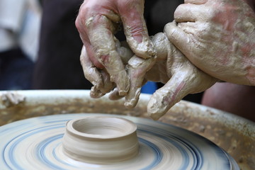 Master of ceramics. We work with clay. The master ceramist teaches the student. Craftsman hands sculpts clay