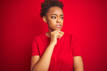 Fototapeta na wymiar Young beautiful african american woman with afro hair over isolated red background Thinking worried about a question, concerned and nervous with hand on chin