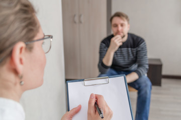 the psychotherapist advises the person, asks questions, interviews the person sitting on the chair....