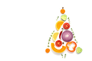 Christmas tree made of pieces of vegetables and fruits on a white background. The concept of vegan and vegetarian food. Top view, flat lay, copy space. Creative layout.