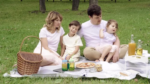 Portrait of a happy family on a picnic on a sunny summer day