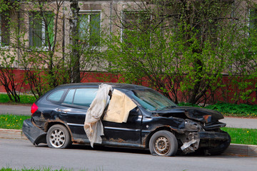 Fototapeta na wymiar crashed car with a dented hood parked on the side of the road