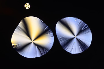 Colorful micro crystals in polarized light. Photo through a microscope.