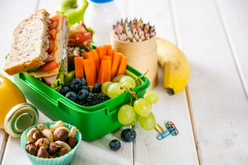 Back to school concept - lunch box with juice, apple and banana, copy space