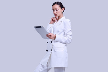 Gorgeous latin women in fashion white suit with digital tablet