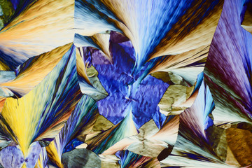Colorful micro crystals in polarized light. Photo through a microscope.