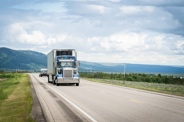 Fototapeta na wymiar Trucking 18 wheeler on highway road in mountain landscape