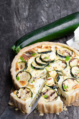 Homemade courgette and feta quiche on rustic wooden table