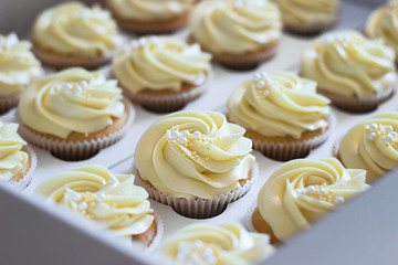 Delicious cupcakes in cardboard box with a hat in the form of a rose