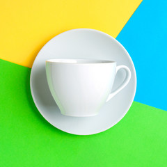 White coffee Cup on blue, yellow and green pastel colorful paper geometric flat background. Drink Cup template for your design to place text, image and logo layout