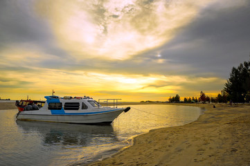 Speed motor boat near the beach over sunset