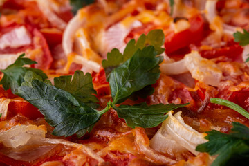 Parsley green herb macro close up on pizza with cheese mozzarella, ham meat, tomato, onion, homemade recipe 