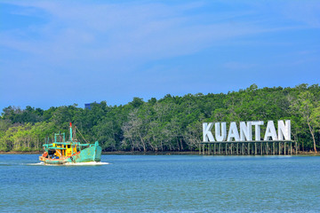 An old, rusty fishing trawler returning to harbor