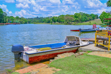 Naklejka na ściany i meble Boat on the lake with green nature background