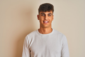 Young indian man wearing sweater standing over isolated white background with a happy and cool smile on face. Lucky person.