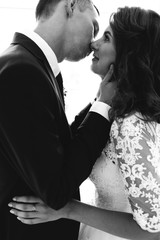 Beautiful bride and groom posing in Studio, first kiss wedding photo shoot