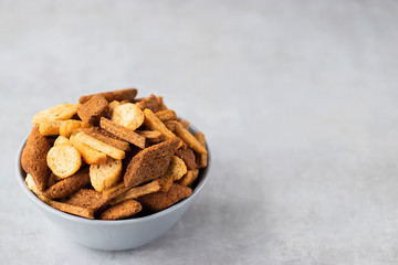 Assorted wheat and rye crackers on a gray background. Salty snack. Snack to beer.