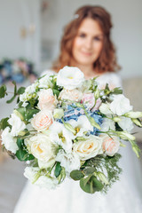 Beautiful bride in a wedding dress with lace, posing in the Studio