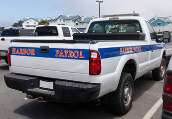 Half Moon Bay, California Harbor Patrol truck parked on quay.