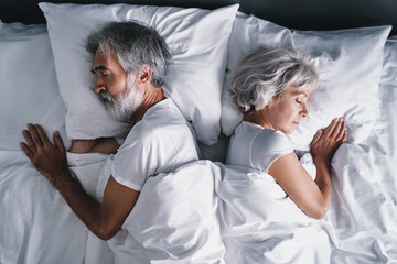 Senior family couple sleeping together in bed.