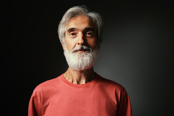 Studio portrait of handsome senior man with gray beard.