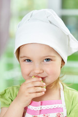 Cute girl eating delicious fresh salad in kitchen