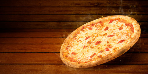 Pizza in flying on wooden table. Concept promotional flyer and poster for Restaurants or pizzerias, template with hot delicious pizza margarita closeup with steam smoke, tasty mozzarella cheese