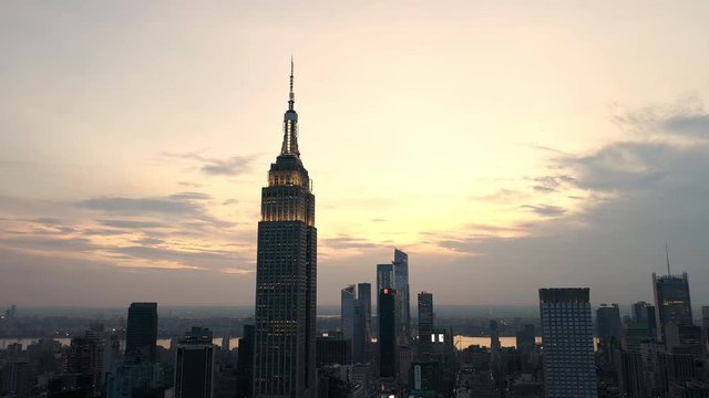 aerial dark city pulling back from Empire State Building at sunset in Manhattan New York NYC