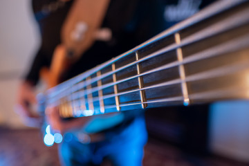 Fototapeta premium Bass player on a studio recording string closeup macro detail session set blu blur background musician composer creative art idea, improvisation blues jazz rock song 