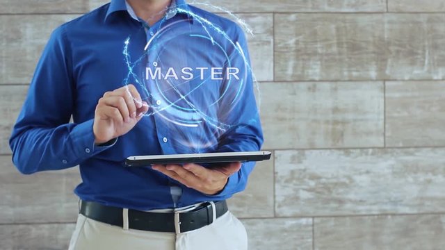 Man activates a conceptual hologram with text Master. The guy in the blue shirt and light trousers with a holographic screen gadget on the background of the wall