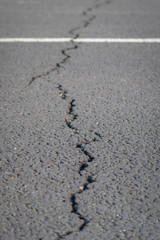 terrible crack in the road pavement, close up blurry background
