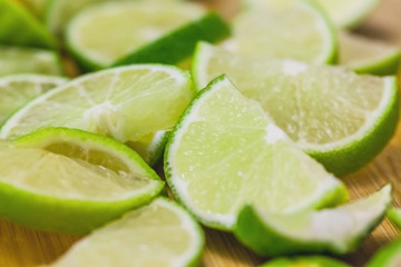 Naklejka na ściany i meble lime slices on wooden table, close up blurry background