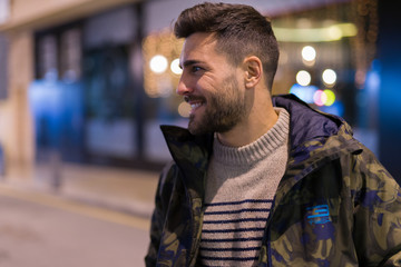 Young handsome man possing and smiling. Street style at night