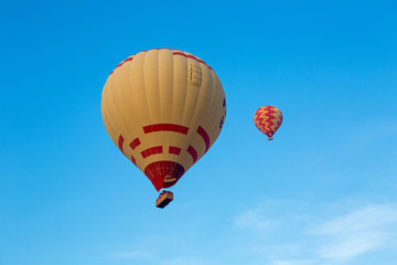 two of flying multicolored hot balloons early morning
