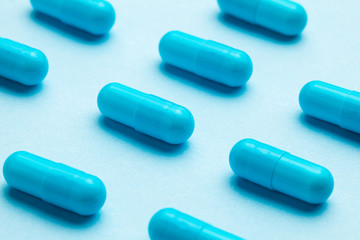 Blue tablets in capsules. Blue background