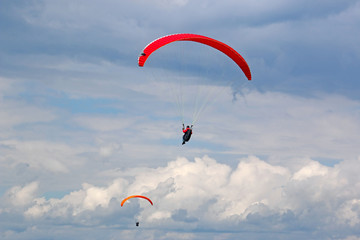 paragliders flying in a cloudy sky