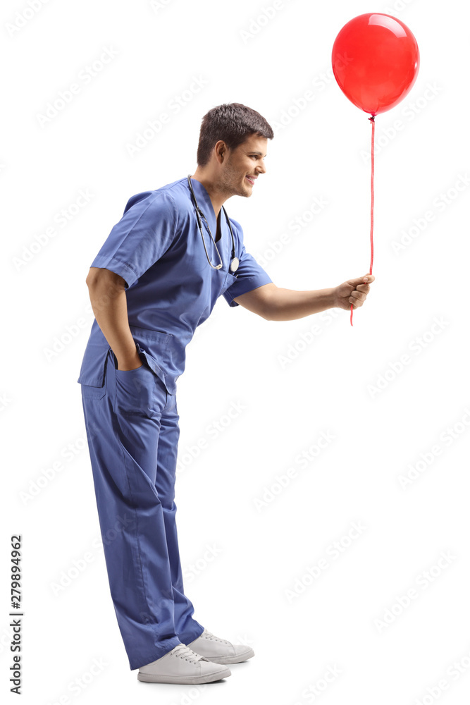 Poster Young male doctor in a blue uniform giving a red balloon