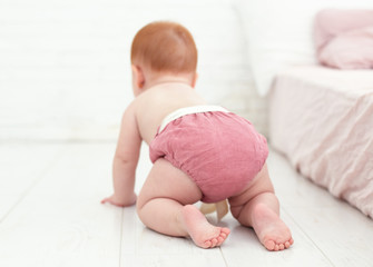 cute, seven months old baby girl crawling on the floor