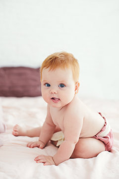 portrait of cute little baby girl sitting on the bed