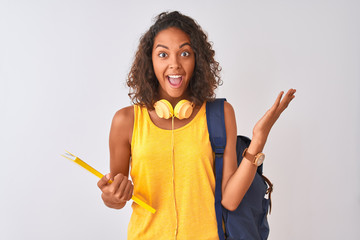 Brazilian student woman wearing backpack holding notebook over isolated white background very happy...