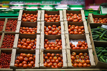 Beautiful red tomatoes in cardboard boxes, for sale on a market shelf
