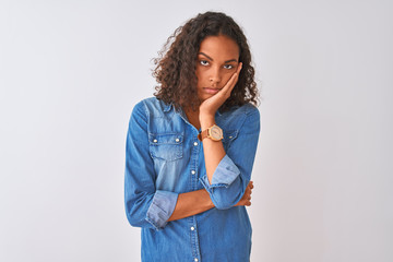 Young brazilian woman wearing denim shirt standing over isolated white background thinking looking tired and bored with depression problems with crossed arms.