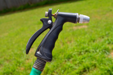 Water hose sprayer attached to a green hose