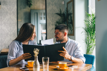 A happy young couple looking at their menu's at a restaurant