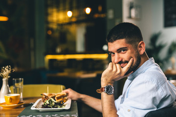 man having dinner or breakfast in restaurant