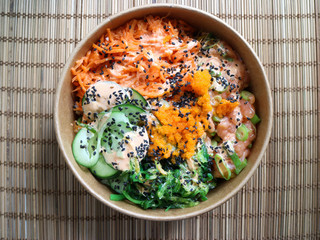 Salmon poke in a bowl with wicker background 
