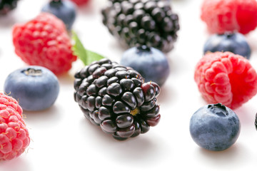 blackberries, raspberries and blueberries on white background
