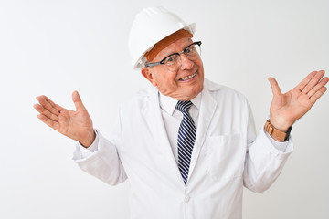 Senior grey-haired engineer man wearing coat and helmet over isolated white background clueless and...